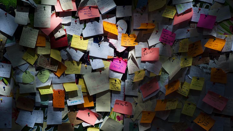 Various colorful sticky notes pinned on a board creating a vibrant display.